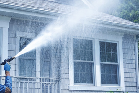 Soft washing residential home exterior siding to remove dirt and mildew