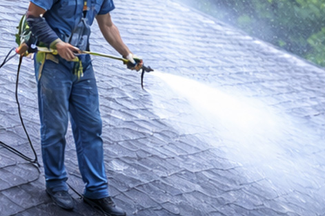 Roof cleaning service removing algae and buildup from residential shingles