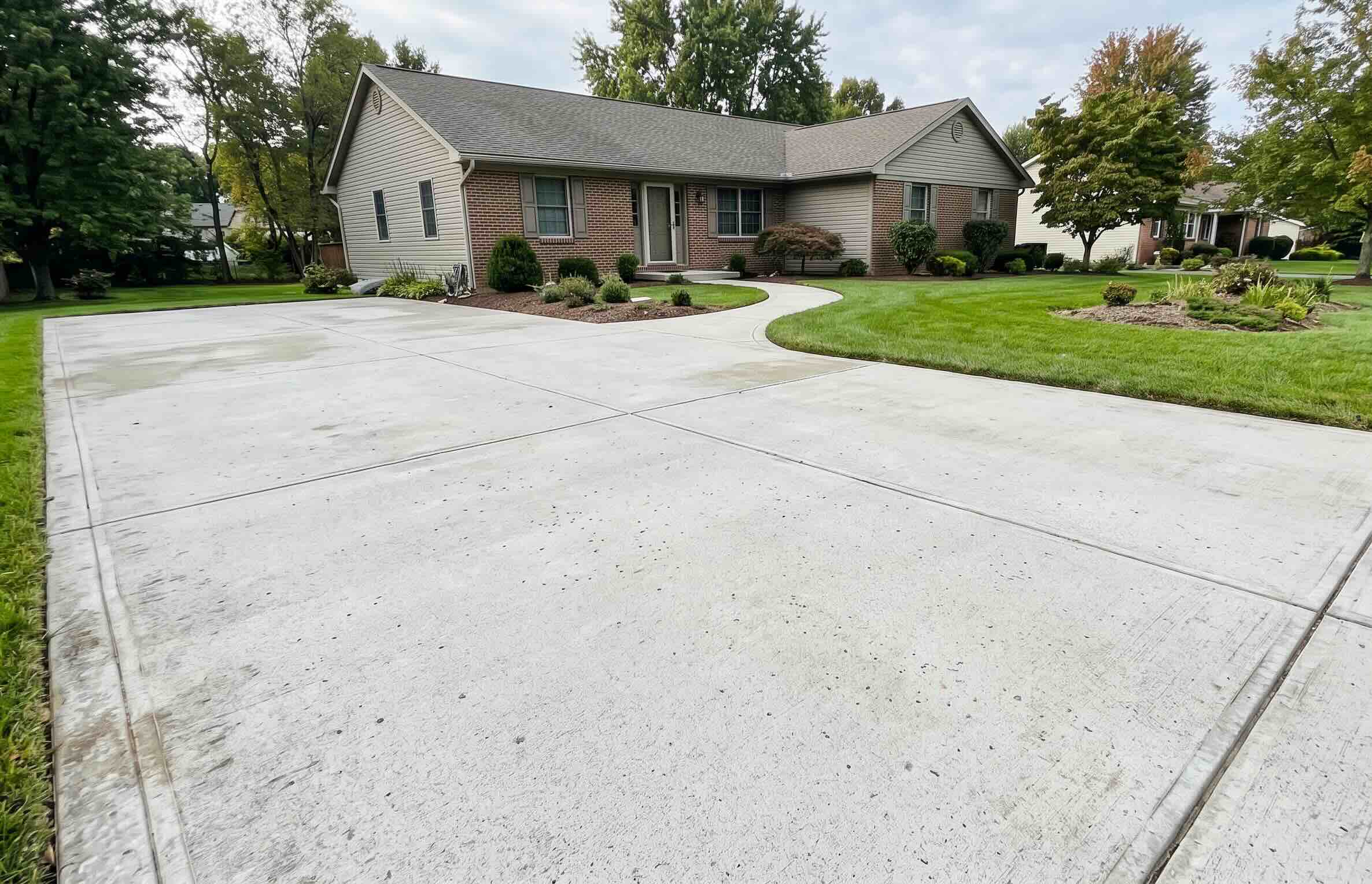 A photo of a suburban property, demonstrating the results of professional concrete cleaning in Harford County MD by Maryland Pickers Power Washing.